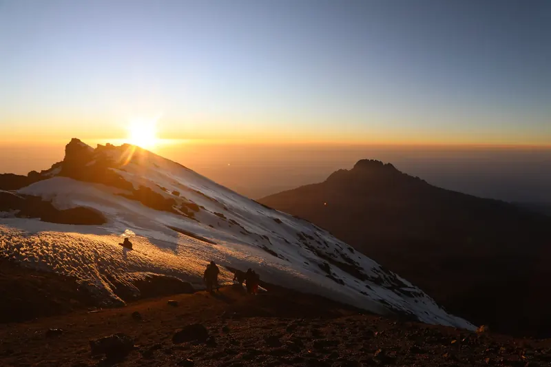 Golden sunrise illuminating the snowy mountain slope
